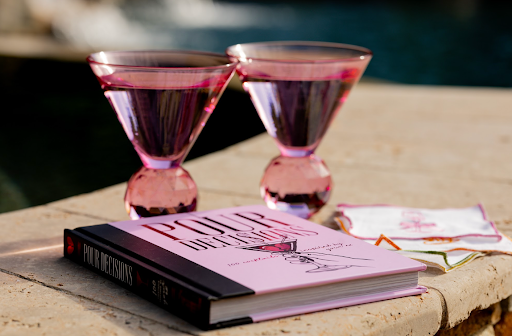 Pour Decisions book with pink tippy glasses by the pool
